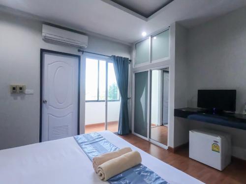 a bedroom with a bed and a tv and a window at Inspire House Hotel in Chiang Mai