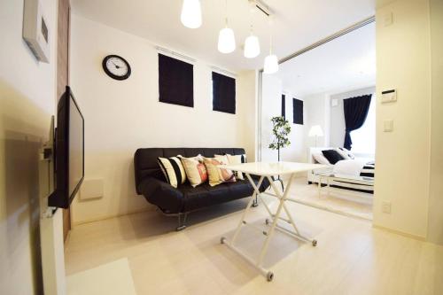a living room with a black couch and a table at Three Tokyo 101 in Tokyo