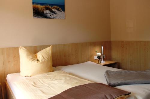 a bedroom with two beds and a picture on the wall at Pension Am Ziegelwall in Bautzen