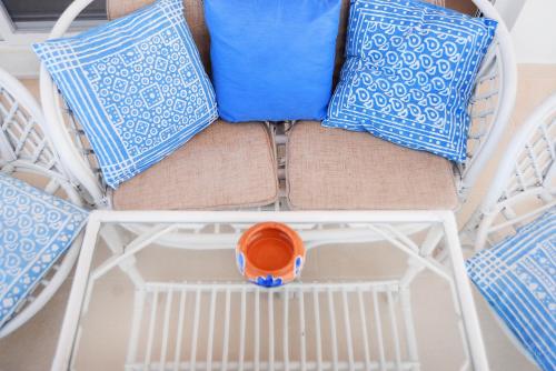 a chair with pillows and an orange cup on it at MOUSELIS APARTMENTS in Kalymnos