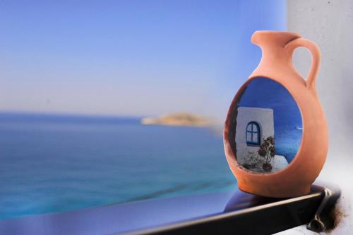 um vaso com um reflexo de uma casa nele em MOUSELIS APARTMENTS em Kalymnos