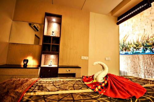 a room with a bed with a red dress on it at Malligi,Hampi in Hospet