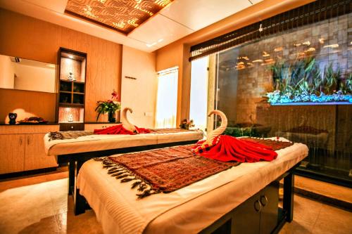 two beds in a room with red dresses on them at Malligi,Hampi in Hospet