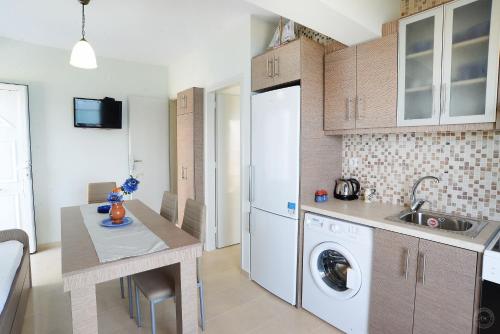 a kitchen with a sink and a washer and dryer at MOUSELIS APARTMENTS in Kalymnos