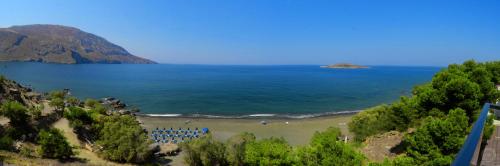 a view of a beach with a bunch of chairs at MOUSELIS APARTMENTS in Kalymnos