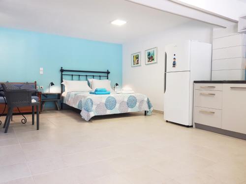 a bedroom with a bed and a kitchen with a refrigerator at Sea Front Studio - Porto Boufalo - Evia in Boufalo