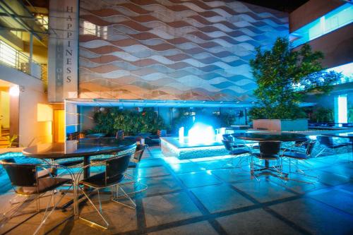 a lobby with tables and chairs and a fireplace at Malligi,Hampi in Hospet