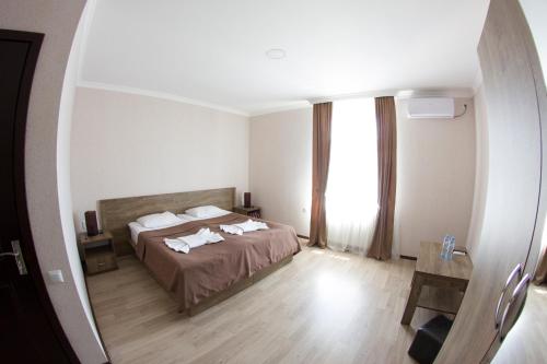una camera da letto con un letto e una grande finestra di Hotel Beni a Akhaltsikhe