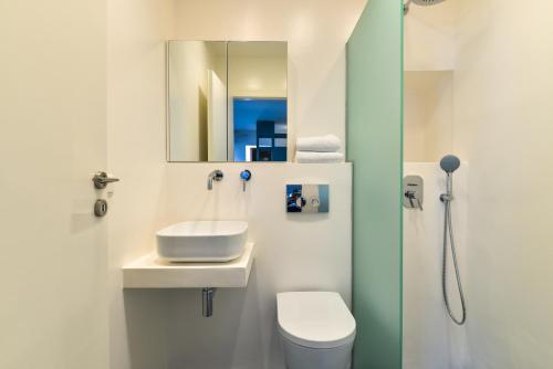 a bathroom with a sink and a toilet and a mirror at Agreli hora in Tinos Town