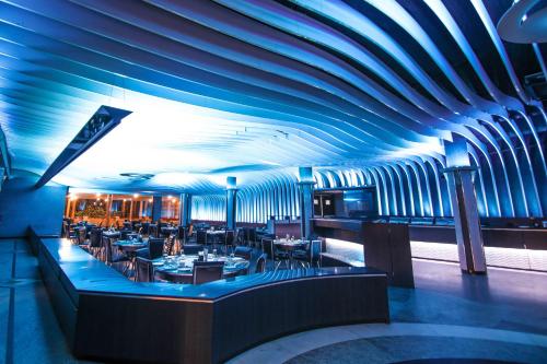 a restaurant with a blue ceiling and tables and chairs at Malligi,Hampi in Hospet