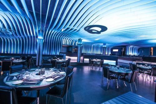 a dining room with tables and chairs and blue ceilings at Malligi,Hampi in Hospet