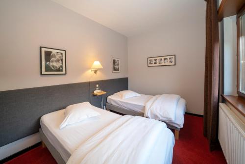 a hotel room with two beds and a window at Hôtel Le Verger De Bischwiller in Bischwiller