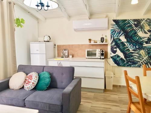 a living room with a couch and a kitchen at Sunshine Suite Boutique - Only 5 Min Walk To The Beach in Eilat