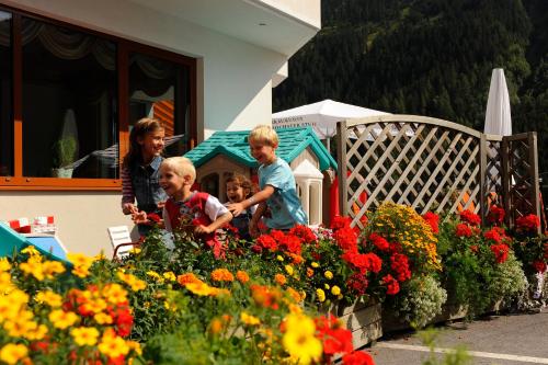 a group of children playing in a garden with flowers at Hotel Post Kappl in Kappl