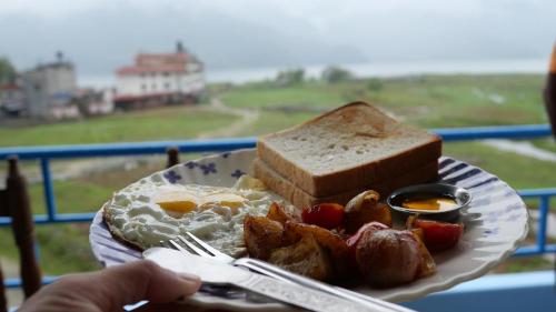 a plate of food with eggs bread and toast at Tranquil Water Guest House in Pokhara