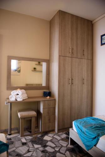 a bedroom with a desk and a mirror at MOUSELIS APARTMENTS in Kalymnos