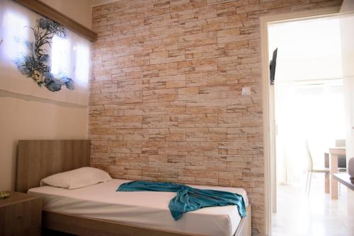 a brick wall in a bedroom with a bed at MOUSELIS APARTMENTS in Kalymnos