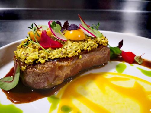 a plate of food with meat and vegetables on it at Hôtel Le Verger De Bischwiller in Bischwiller