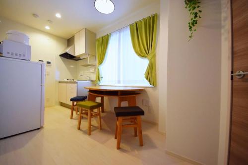 a kitchen with a table and chairs and a window at Three Tokyo 102 in Tokyo