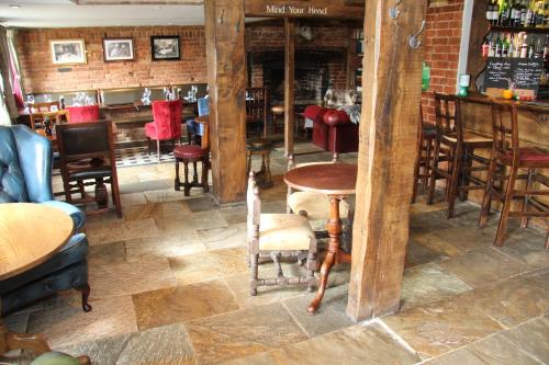 a room with a table and chairs and a bar at The Vineyard Lamberhurst in Lamberhurst