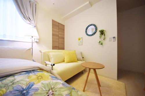 a bedroom with a bed and a table and a couch at Three Tokyo 102 in Tokyo