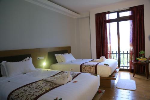 a hotel room with two beds and a window at Haile Resort-Gondar in Gonder