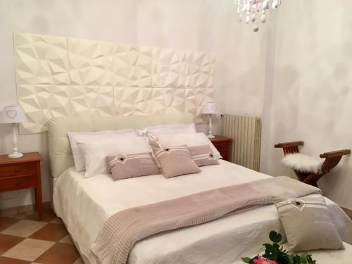 a bedroom with a large white bed with two pillows at Rossella alla Villarella dei Tulipani in Asti