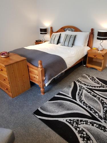- une chambre avec un grand lit et un tapis dans l'établissement Delny Muir House, à Invergordon