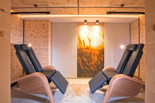 two chairs in a room with a painting on the wall at Hotel Truyenhof in Ried im Oberinntal