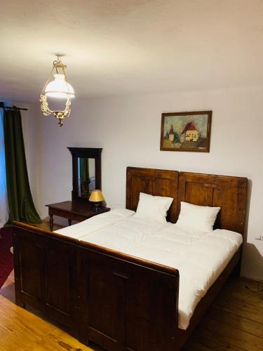 a bedroom with a large bed with white sheets at Casa Teutsch in Sighişoara