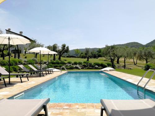 einen Pool mit Stühlen und Sonnenschirmen in einem Resort in der Unterkunft Relais Casale Valigi in Narni