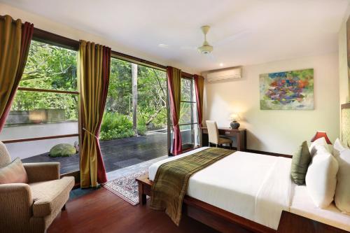 a bedroom with a bed and a large window at Gending Kedis Luxury Villas & Spa Estate in Jimbaran