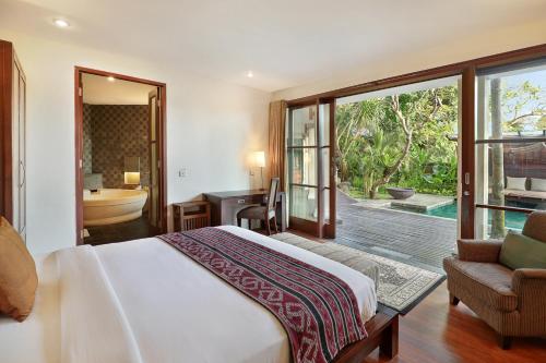 a bedroom with a bed and a bathroom with a tub at Gending Kedis Luxury Villas & Spa Estate in Jimbaran