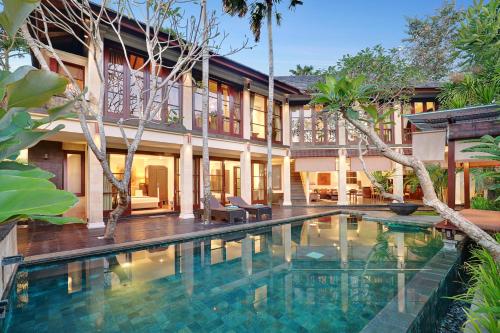 an exterior view of a house with a swimming pool at Gending Kedis Luxury Villas & Spa Estate in Jimbaran