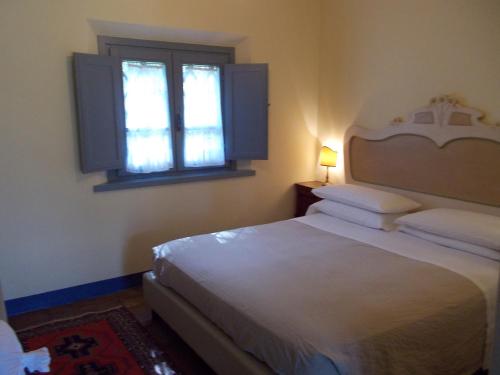a bedroom with a white bed and a window at Alloggio Al San Girolamo in Longiano