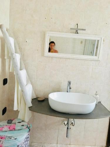 a person taking a picture of a sink in a bathroom at Rossella alla Villarella dei Tulipani in Asti