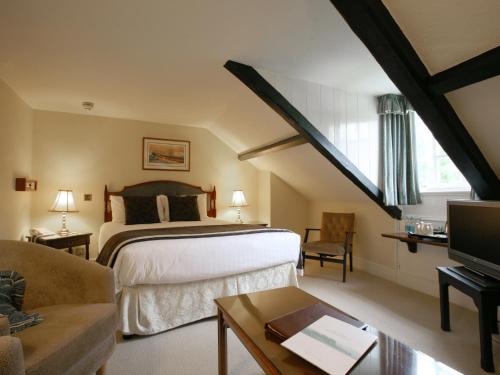 a bedroom with a bed and a couch and a tv at The Rock Inn in Bovey Tracey
