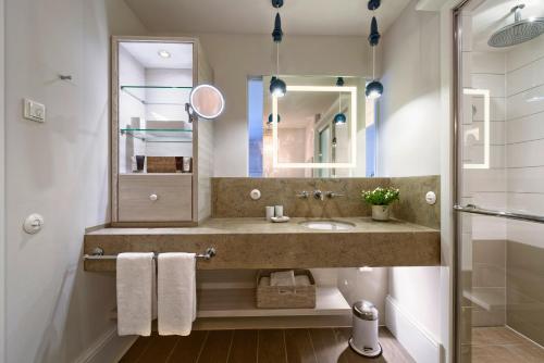 a bathroom with a sink and a mirror at Weissenhaus Private Nature Luxury Resort in Weißenhaus
