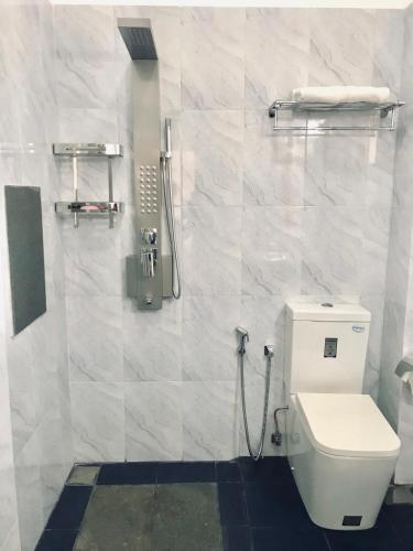 a bathroom with a toilet and a shower at Duvi's Shelter Bungalow in Colombo