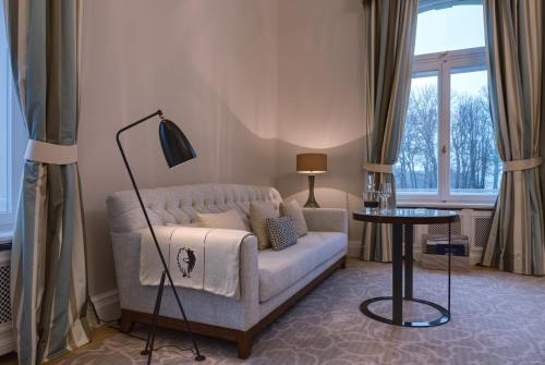 a living room with a couch and a lamp at Weissenhaus Private Nature Luxury Resort in Weißenhaus