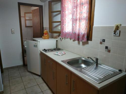 a kitchen with a sink and a refrigerator at Apartmets Sunwaves in Kerveli