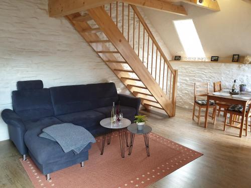 ein Wohnzimmer mit einem blauen Sofa und einem Tisch in der Unterkunft Ferienwohnung Fritzer in Ellenz-Poltersdorf
