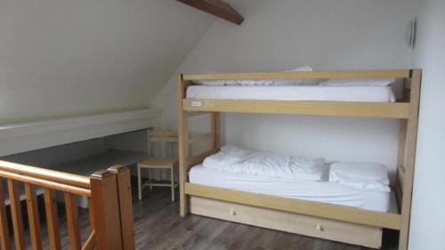 ウルガットにあるCentre de Vacances CPCV Normandie à 50 metres de la plage de Houlgateの二段ベッド2台とベビーベッド1台が備わる客室です。