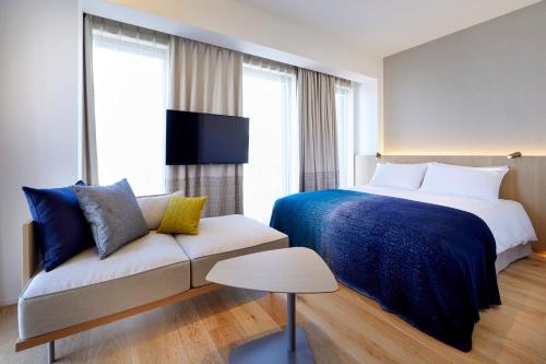 a hotel room with a bed and a couch at TSUKI Tokyo in Tokyo