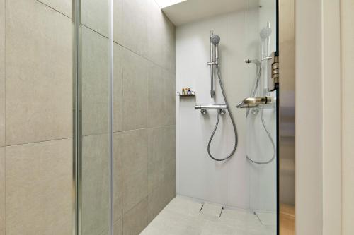 a bathroom with a shower with a glass door at TSUKI Tokyo in Tokyo