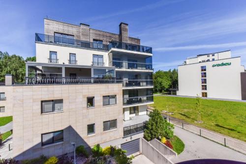 an apartment building with a hill in the background at Amber - Luxury Two Bedroom Apartment in Palanga