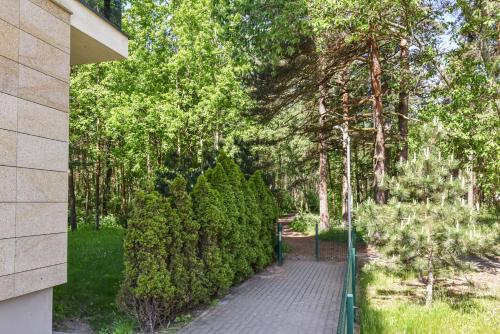 a brick walkway in a park with trees at Amber - Luxury Two Bedroom Apartment in Palanga