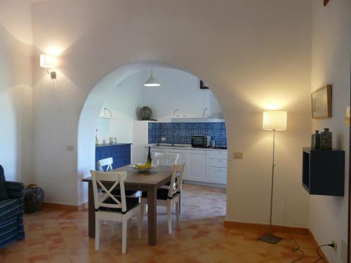 a kitchen and dining room with a table and chairs at Residence Salina in Malfa