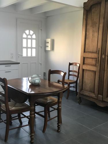 a dining room with a table and chairs and a kitchen at Appartement récent, proche centre ancien in Bayonne