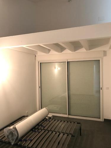 Cette chambre dispose d'une grande fenêtre avec des stores. dans l'établissement Appartement récent, proche centre ancien, à Bayonne